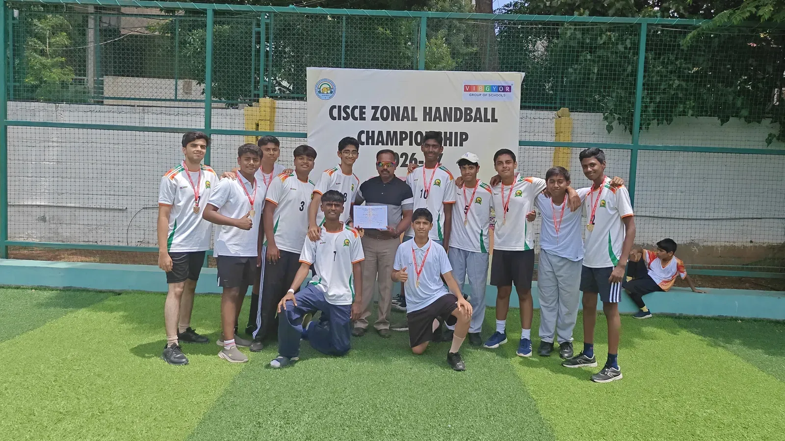 GSSE handball players celebrating with their trophies