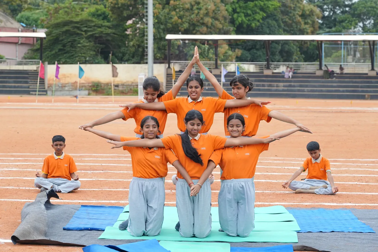 Students and teachers performing yoga asanas on International Yoga Day