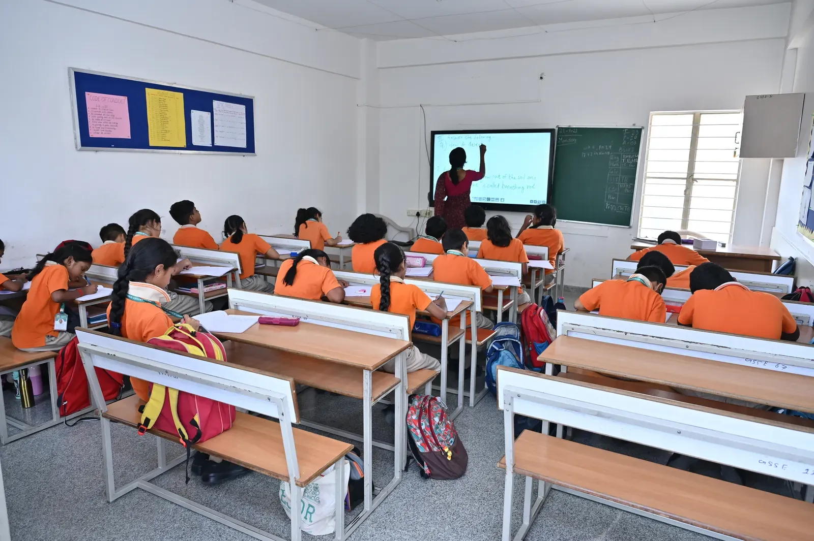 Students presenting at a digital board in the classroom