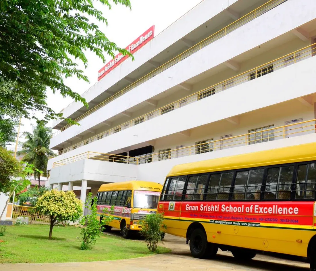 The Gnan Srishti School of Excellence building, with the school buses parked outside